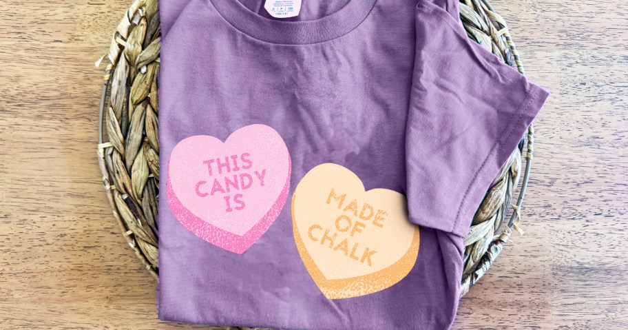 purple folded graphic tee with conversation hearts on it