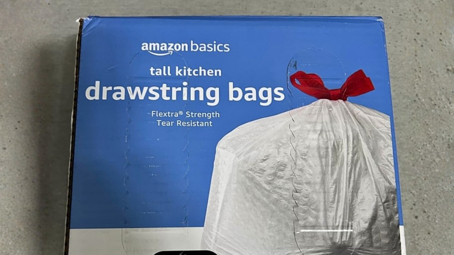 a box of amazon basics tall kitchen trash bags