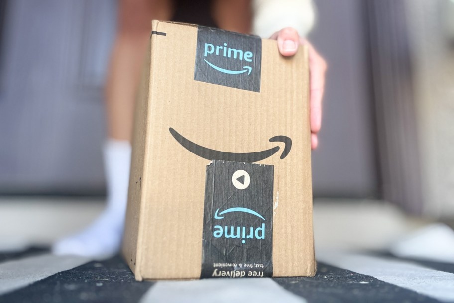A hand holding up an Amazon box.