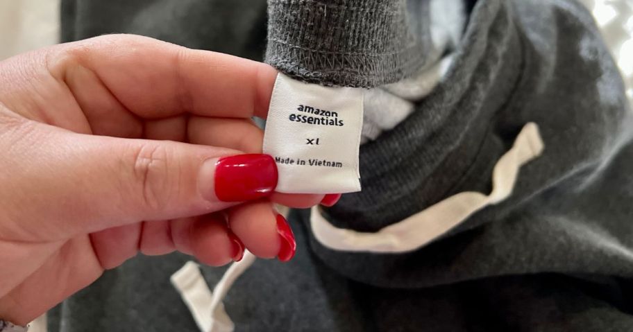 hand holding amazon essentials label on clothing