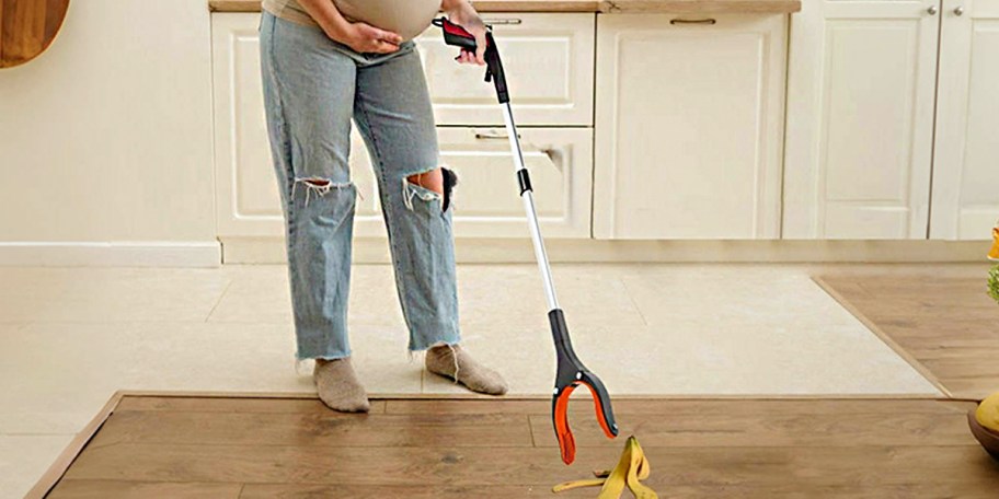 woman using grabber tool to pick up banana 