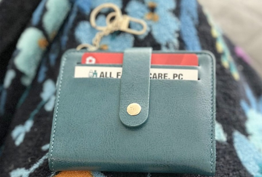 blue wallet laying on blanket 