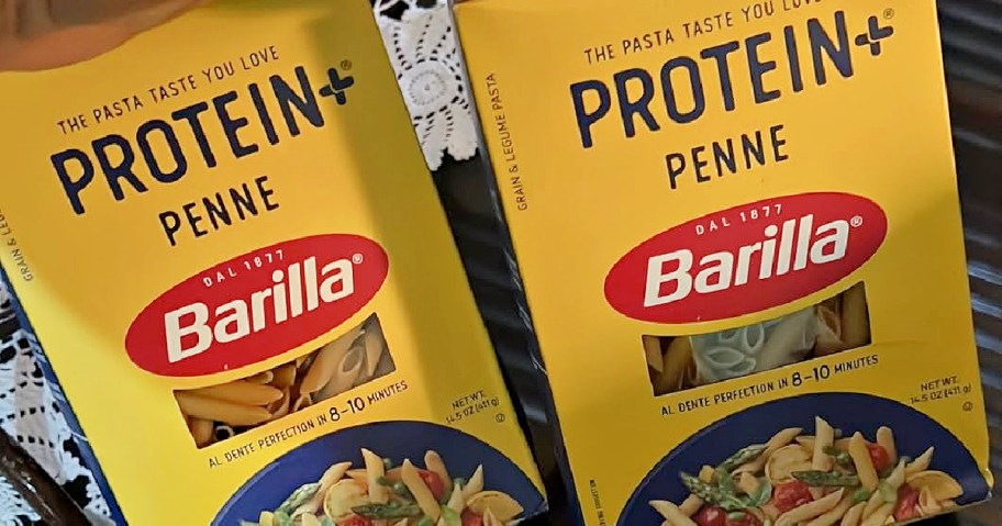 Two boxes of Barilla Protein Penne pasta, with vibrant yellow packaging featuring the brand name and product details.