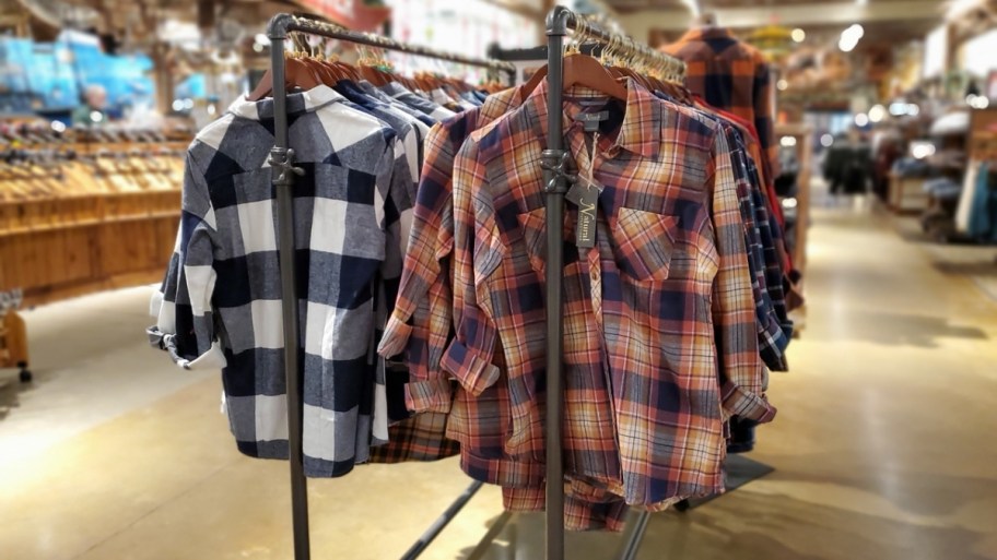 flannel shirts hanging on a clothing rack in a store