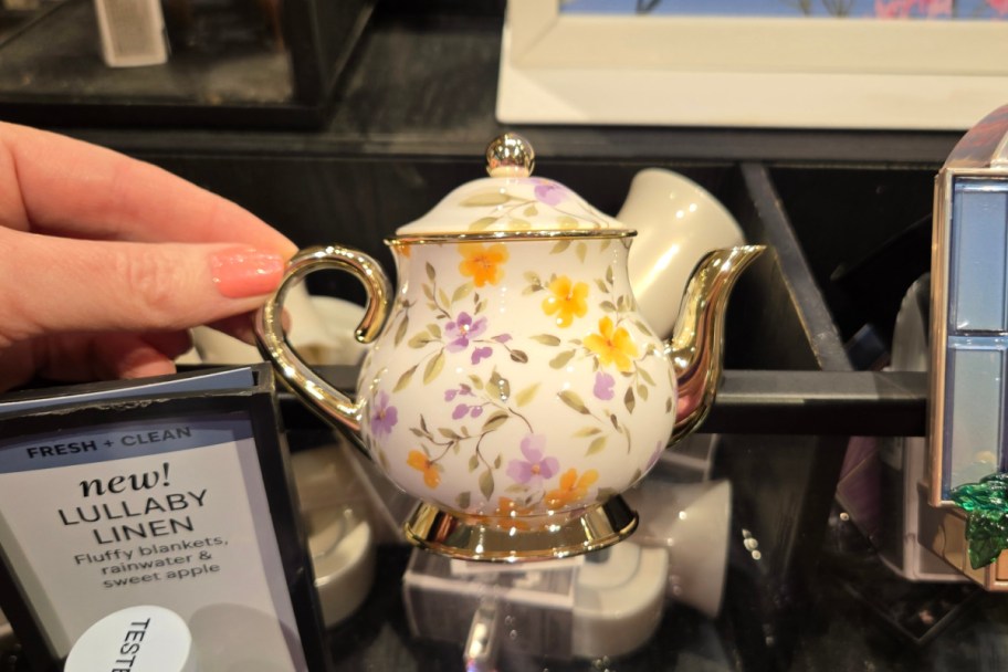 hand holding mini teapot wall plug