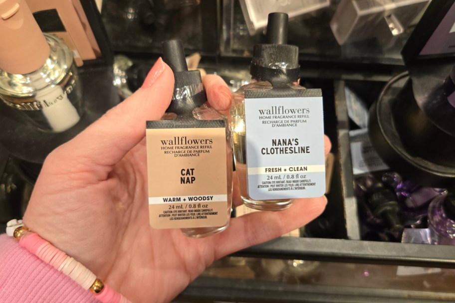 hand holding two wall plug in scents