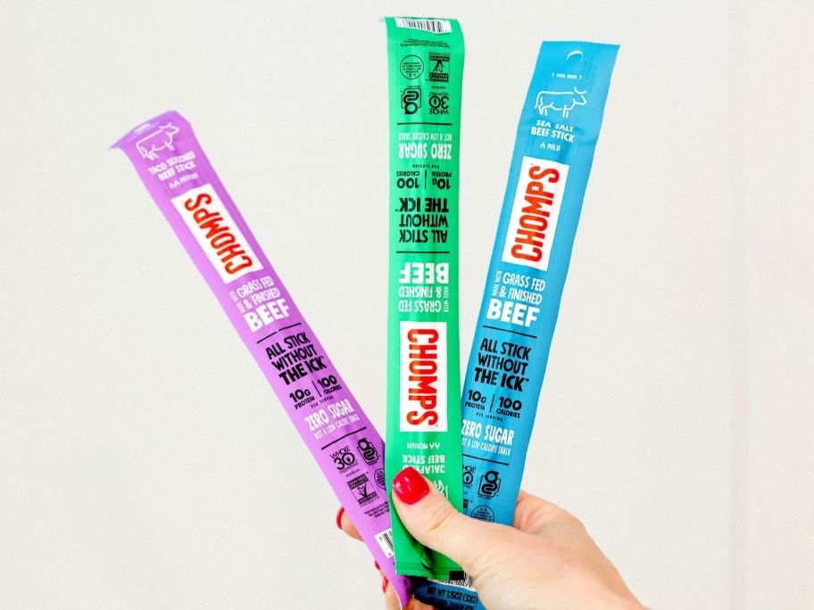 hand holding three chomps beef sticks