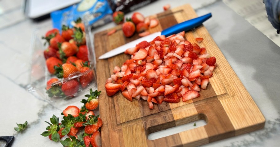 chopping strawberries on a cutting board 