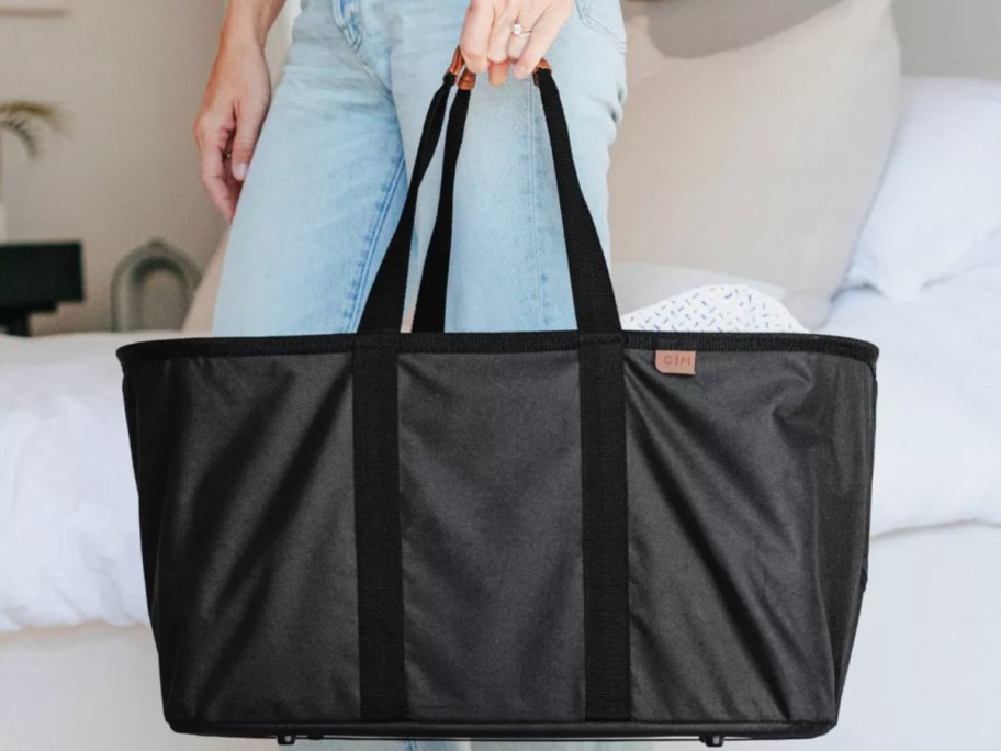hand holding large black laundry basket tote with handles