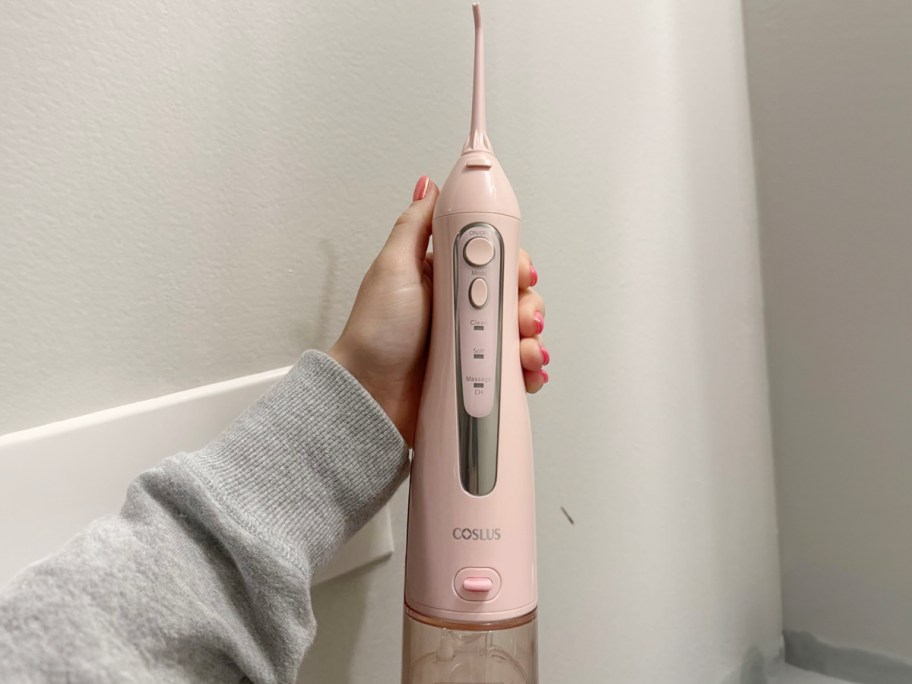 hand holding pink waterpik