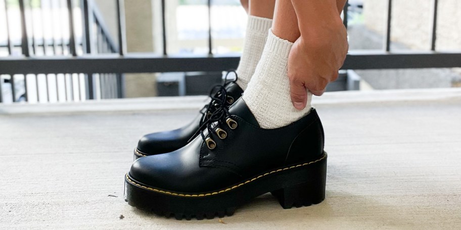 person wearing black doc martens