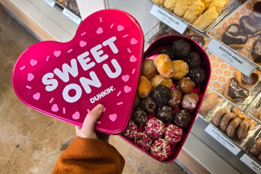 hand holding heart tin filled with donut holes