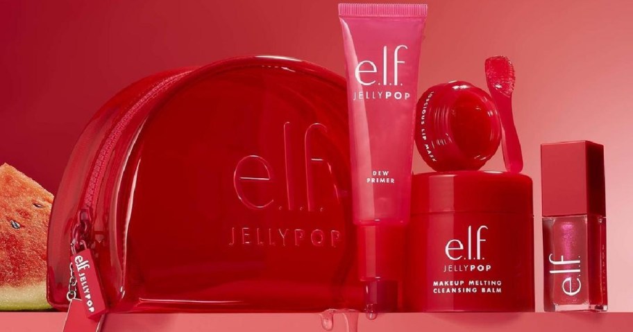 Red e.l.f. Jelly Pop cosmetic set includes a makeup bag, dew primer, cleansing balm, lip gloss, and nail polish, with a watermelon backdrop.