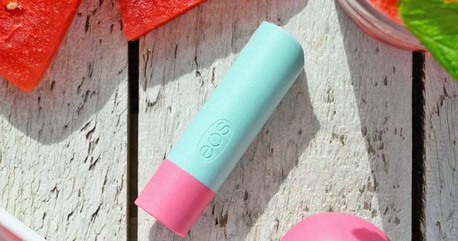 eos lip balm on a table near watermelon slices