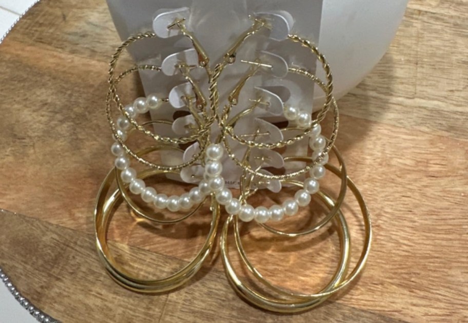 Two sets of multiple styles of gold hoop earrings.