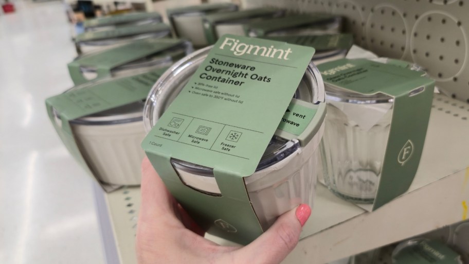 womans hand holding a white stoneware overnight oats container