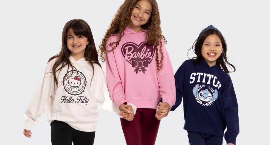 three girls wearing character sweatshirts