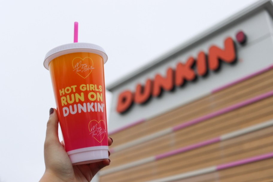hand holding up a dunkin cup