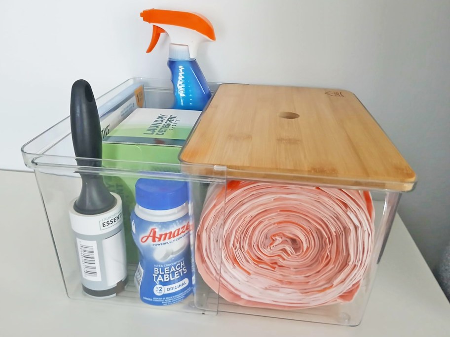 roll of trash bags and cleaning products in an acrylic organizer