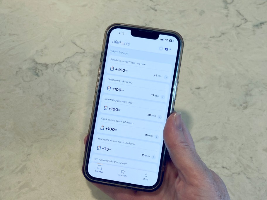 holding a phone open to a survey app