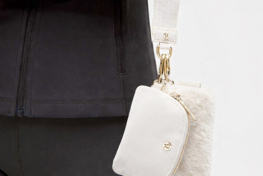 woman holding a white dual pouch wristlet