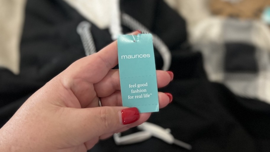 womans hand holding a maurices tag