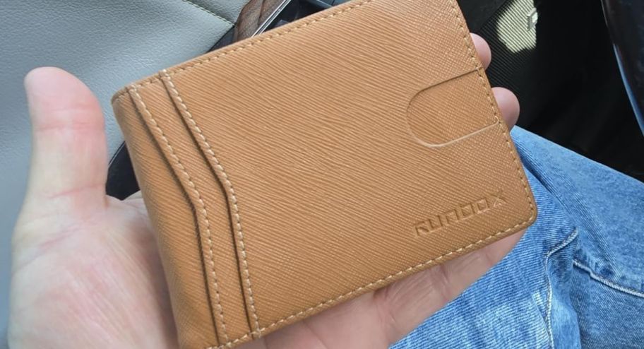 hand holding mens wallet while int he car