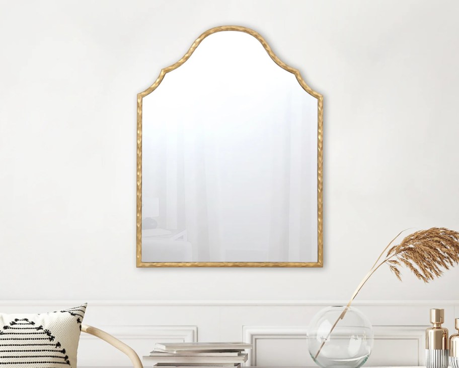 gold arch mirror on wall