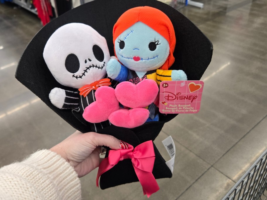 A hand holding up a Nightmare Before Christmas plush bouquet at Walmart.