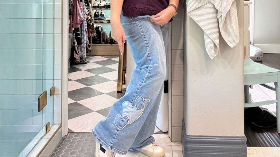 a woman in a pair of jeans with heart patches on the leg