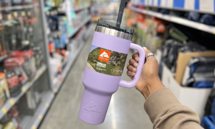 womans hand holding a purple 40oz tumbler