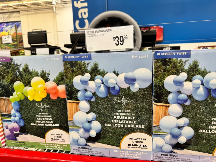 rainbow and blue reusable balloon garlands in boxes on a store display