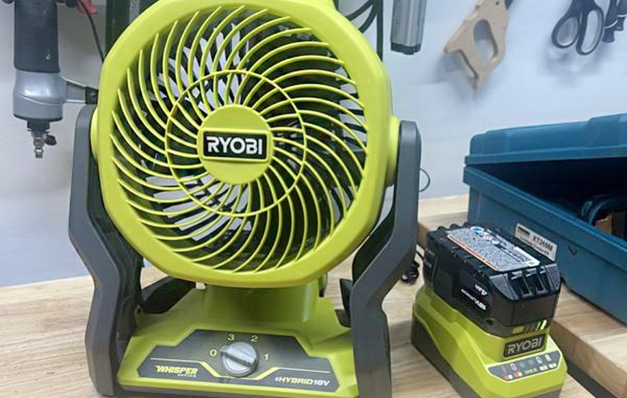 green and black fan with charger on table
