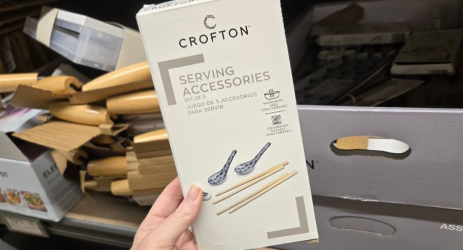 hand holding serving accessories inside of its box