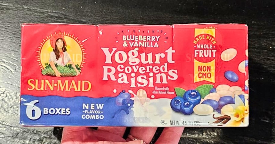 hand holding a box with 6 Sun-Maid Blueberry & Vanilla Yogurt Covered Raisin packs in it