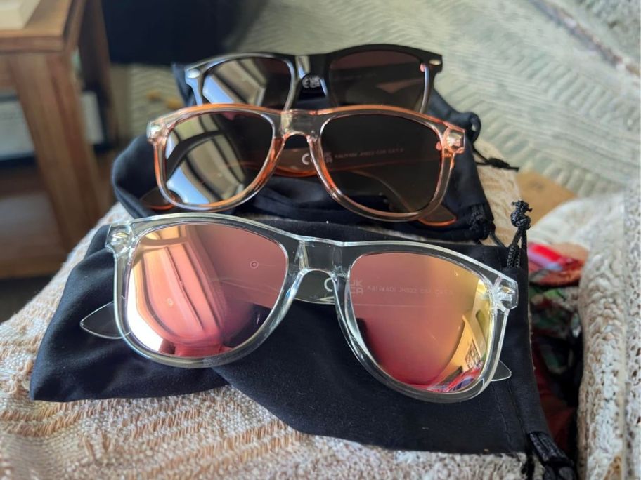 three women's sunglasses on bed