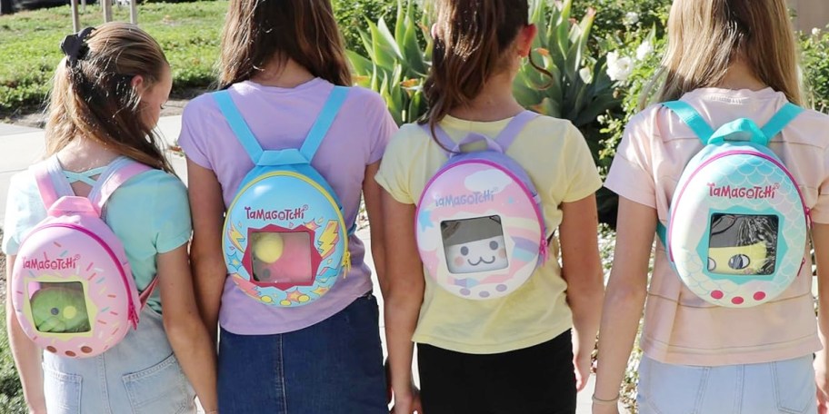girls wearing tamagotchi backpacks walking outside 