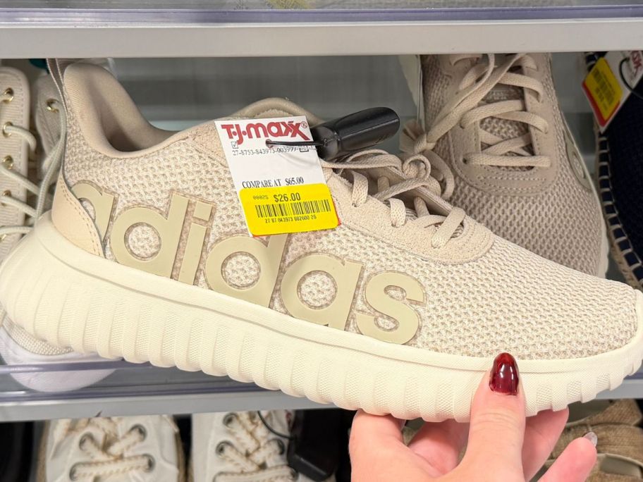 hand holding adidas shoe in tj maxx store