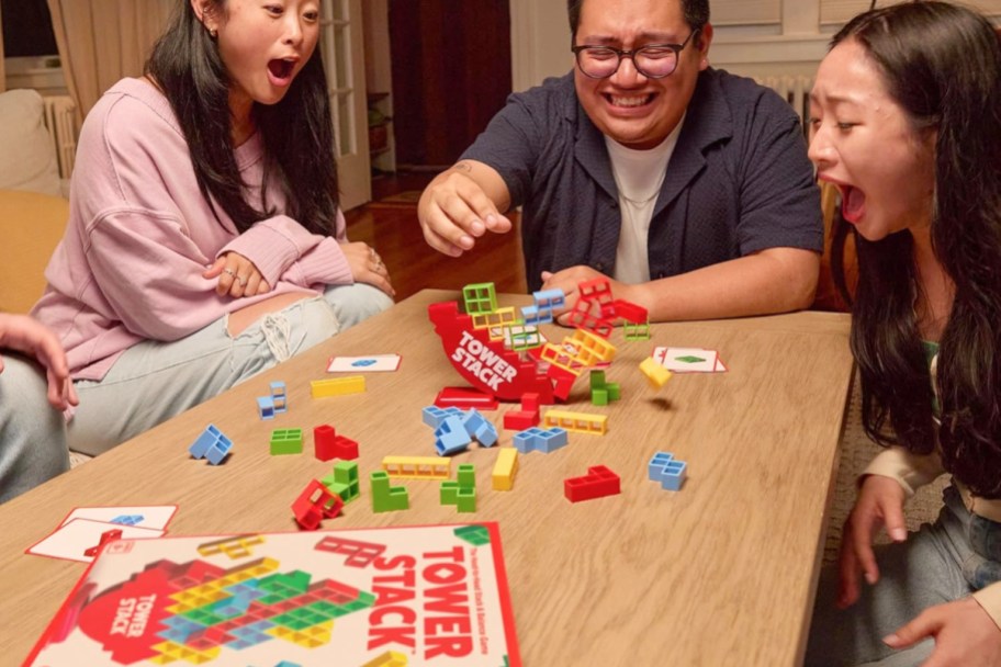 people at a table playing a tower stack game