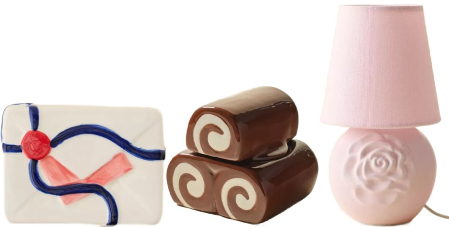 Three decor pieces from Urban Outfitters. A trinket box, a cake rolls candle and a pink lamp.