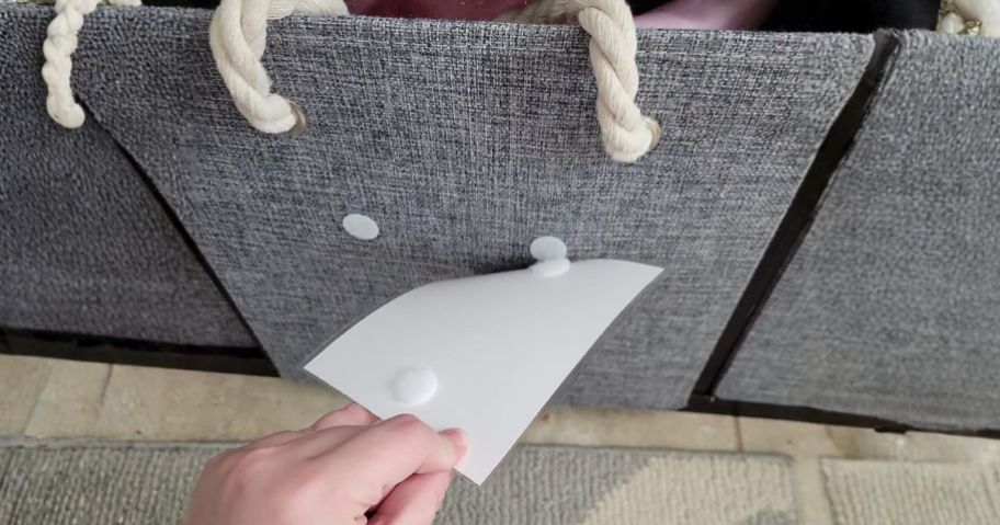 hand pulling label off of basket