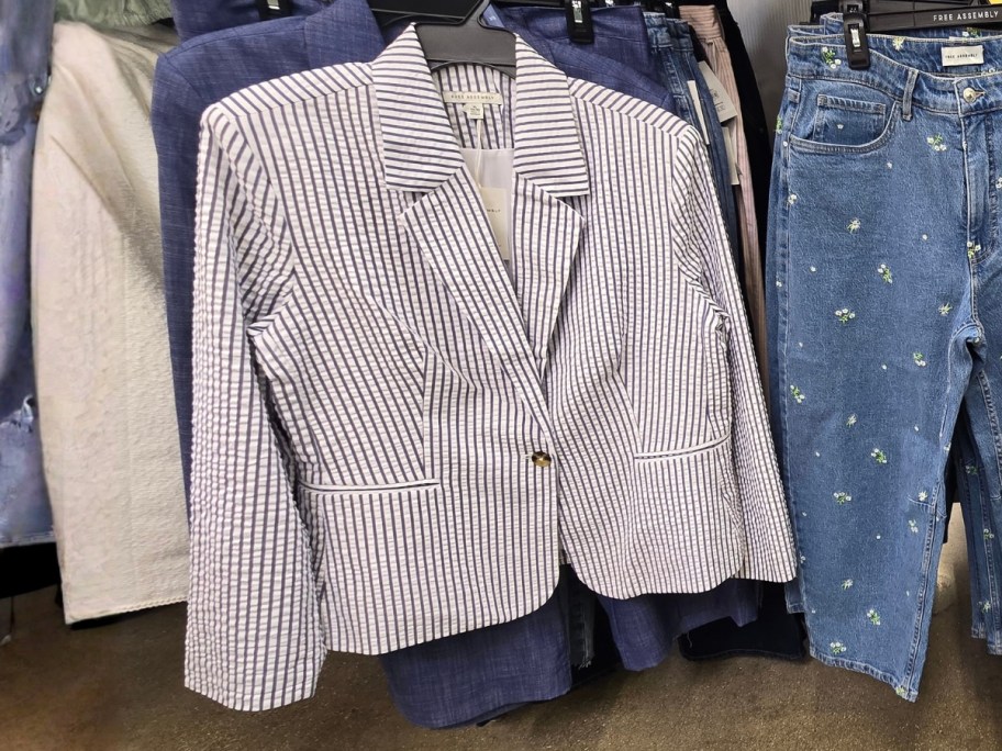 a women's blue and white seersucker blazer hanging on a store display