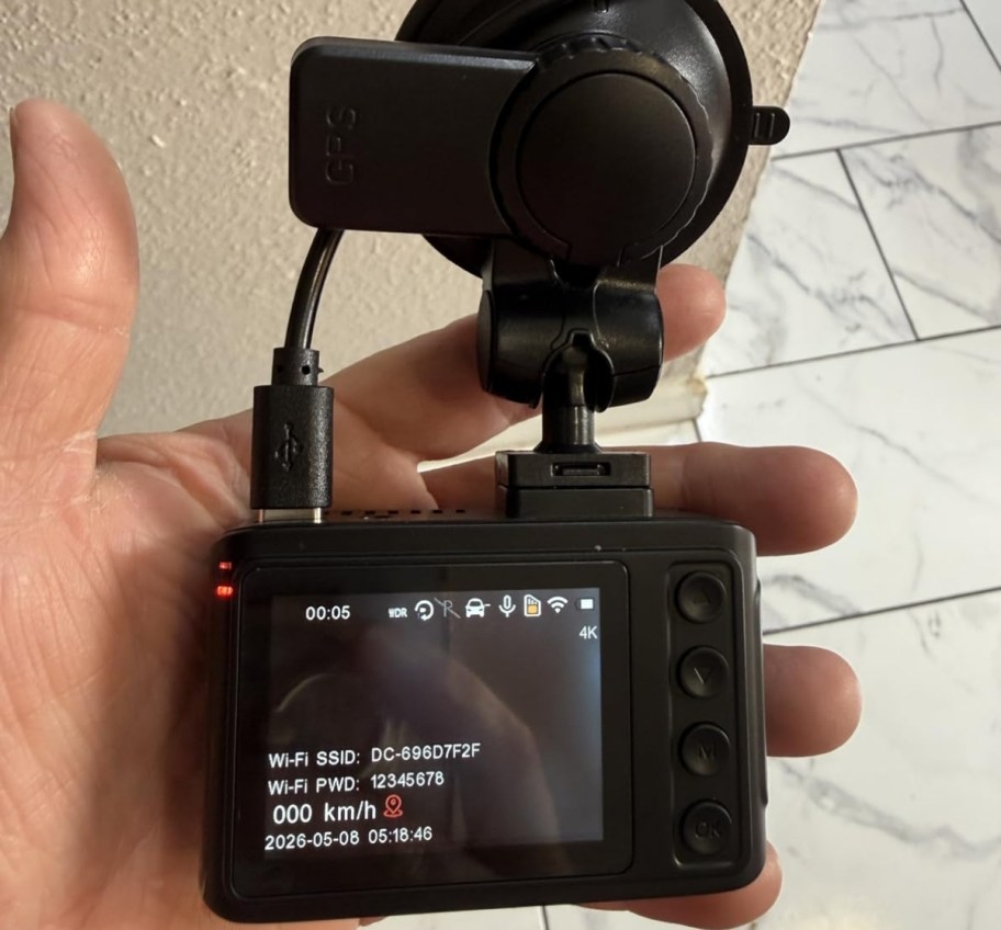 a hand holding a dash cam
