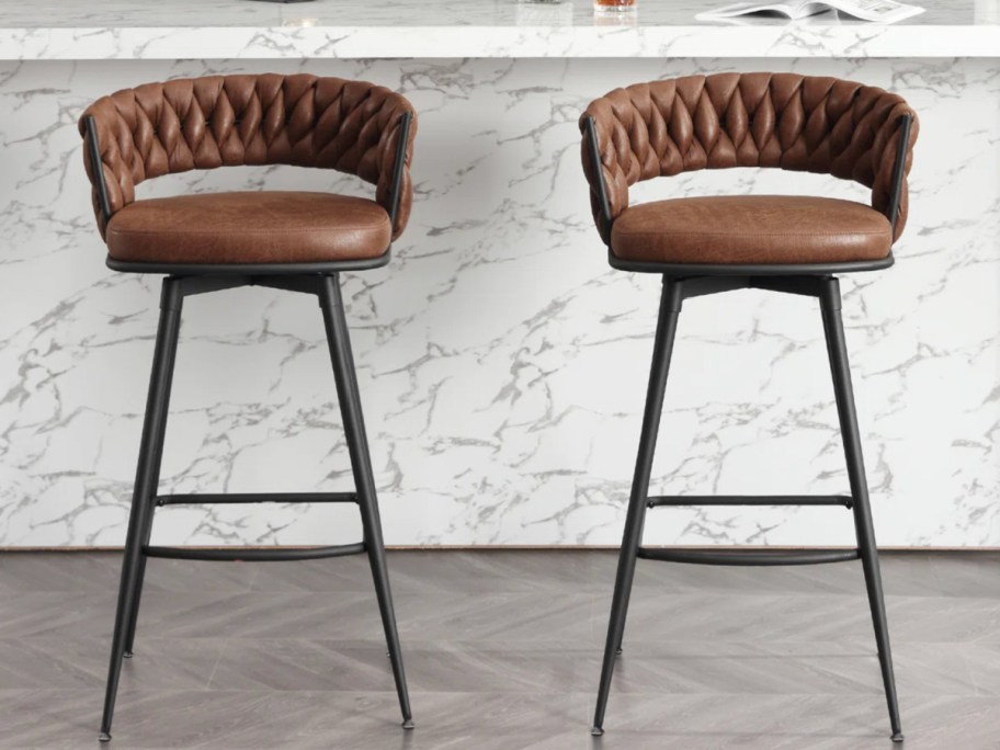 two dark brown leather round bar stool chairs with metal legs