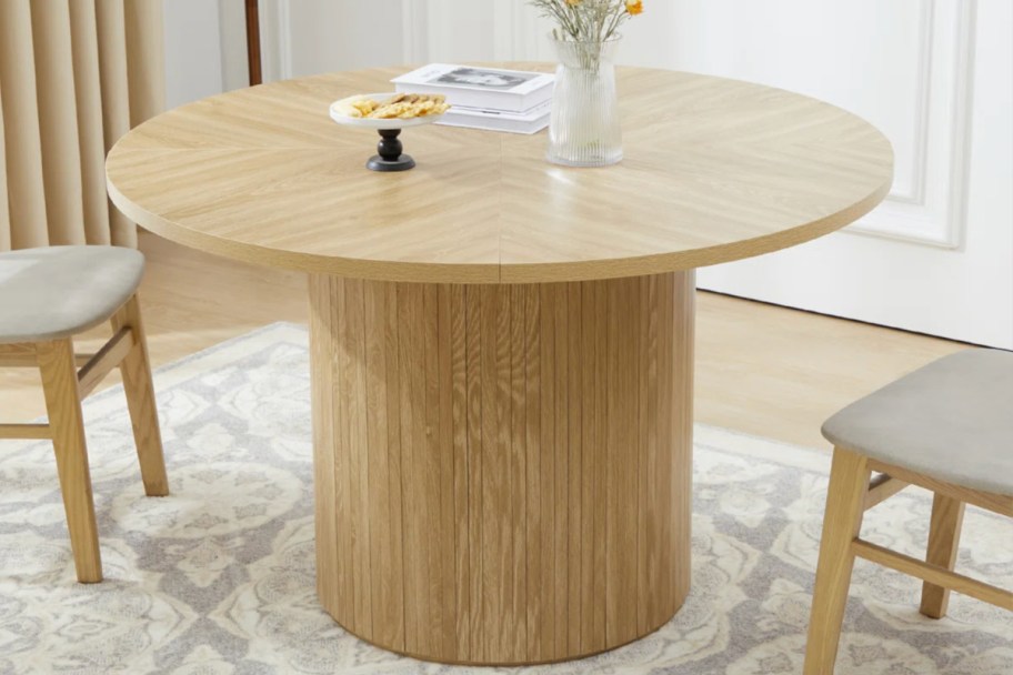 natural wood round pedestal table with two chairs
