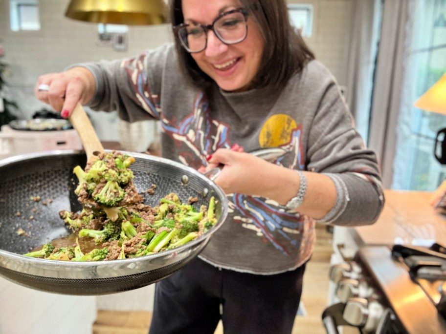 woman making beef and broccoli in a skillet 