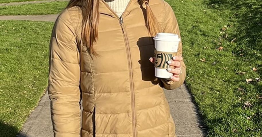 Woman wearing an Amazon Essentials Packable Puffer Jacket while holding a Starbucks Coffee
