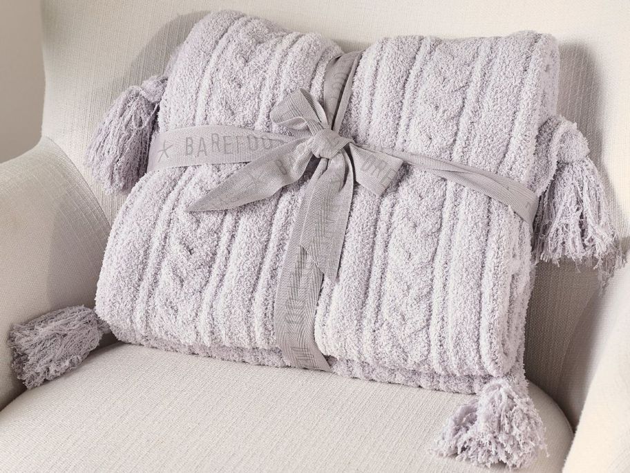 A folded Barefoot Dream Throw Blanket with a ribbon