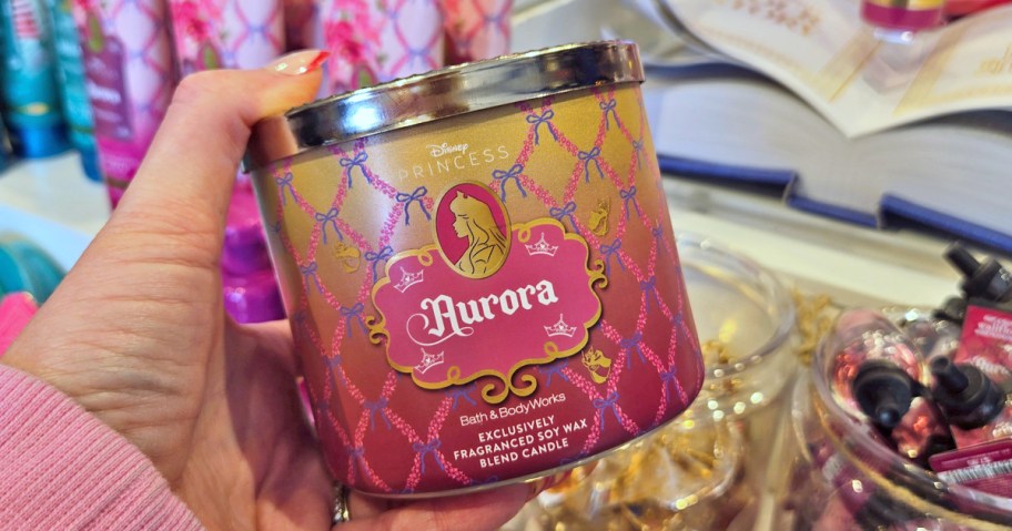 hand holding up a disney princess themed candle in store
