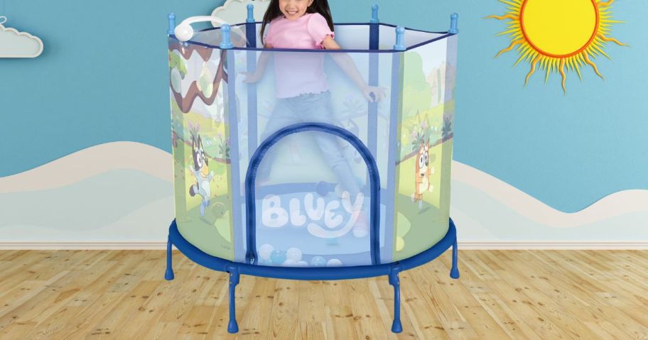 kid jumping in Bluey 4' Trampoline w/ Soft Play Balls in playroom